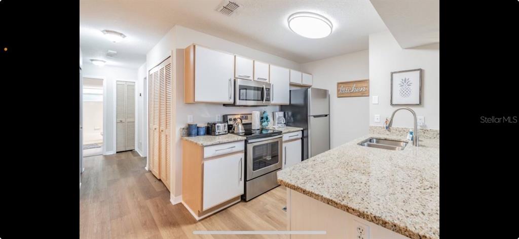 8713 Rockingham Terrace, Unit D Kissimmee, FL 34747 - Photo 14 of 14 a kitchen with stainless steel appliances granite countertop a stove and a sink