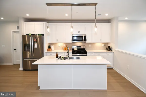 a kitchen with stainless steel appliances a sink a stove a refrigerator and cabinets