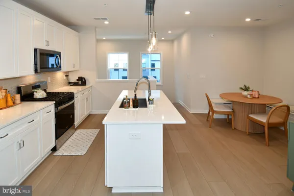 a kitchen with a sink a stove and chairs