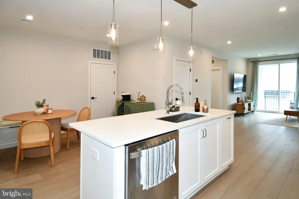 a very nice looking dining room with a table chairs and a kitchen