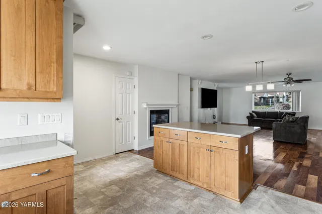 a large living room with stainless steel appliances kitchen island a fireplace