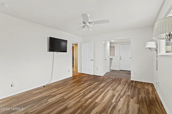 a view of a livingroom with wooden floor and a ceiling fan