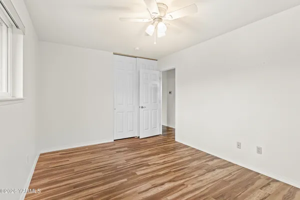 a view of a room with wooden floor and ceiling fan