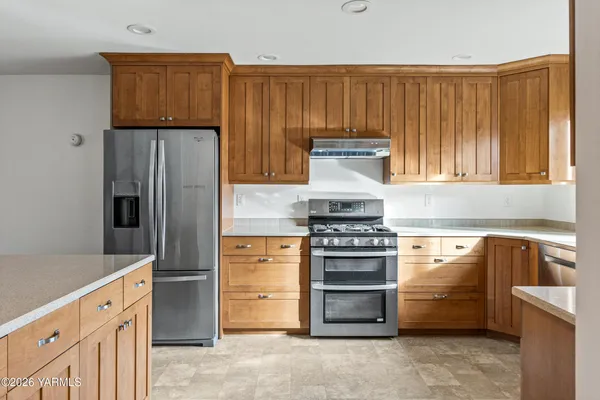a kitchen with stainless steel appliances wooden cabinets and a stove top oven