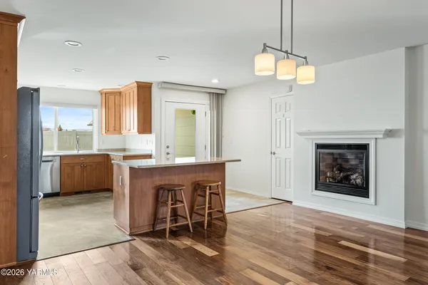 a living room with furniture a fireplace and a open kitchen view