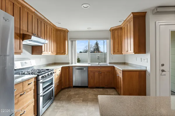 a kitchen with stainless steel appliances granite countertop a stove a sink and a microwave