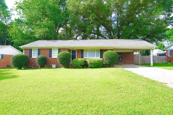 a front view of a house with a yard and trees