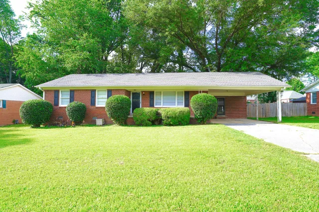 a front view of a house with a yard and trees