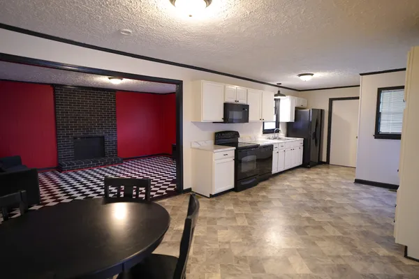 a kitchen with stainless steel appliances granite countertop a stove refrigerator and microwave