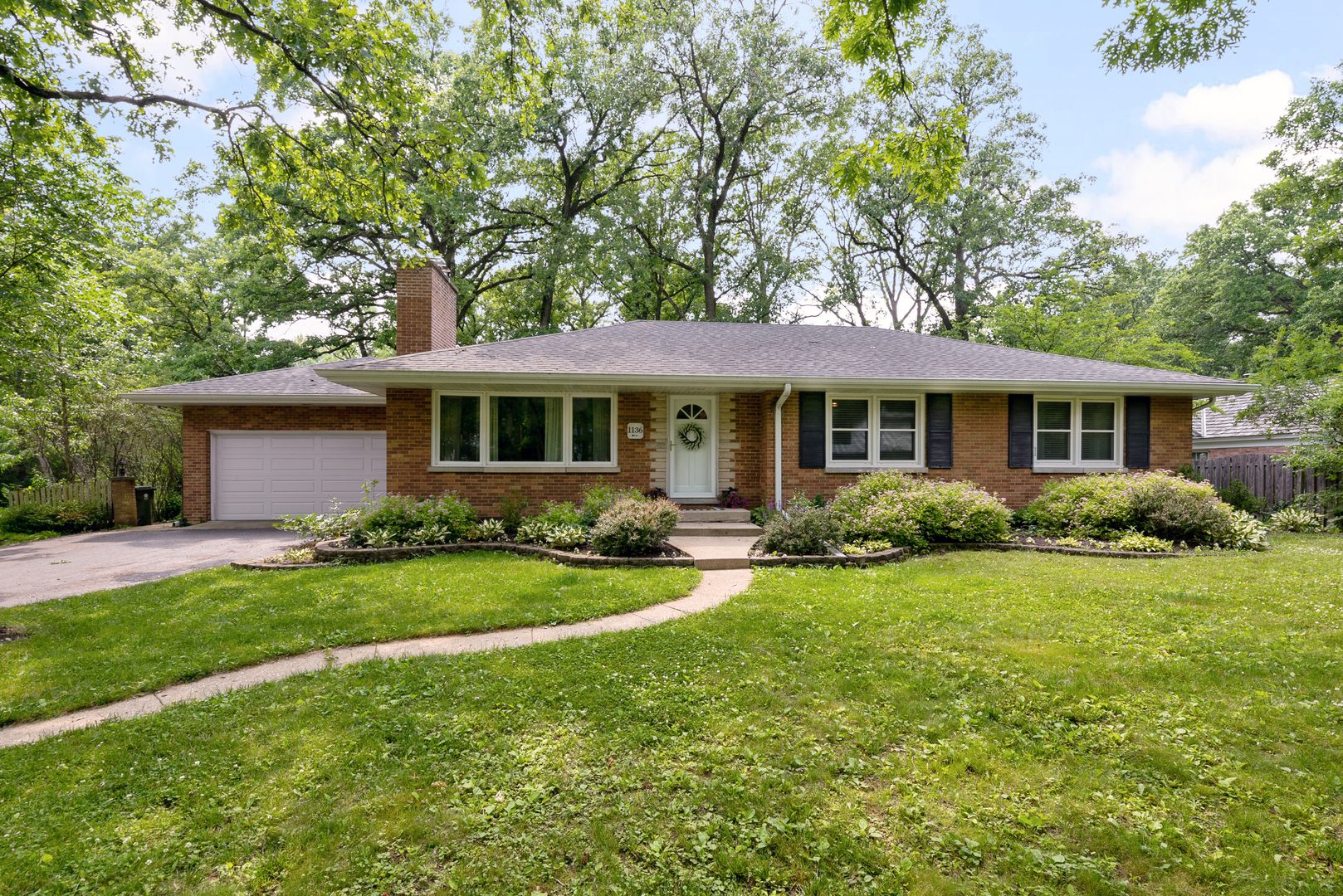 1136 Waveland Road Lake Forest, IL 60045 - Photo 2 of 18 a front view of a house with a garden
