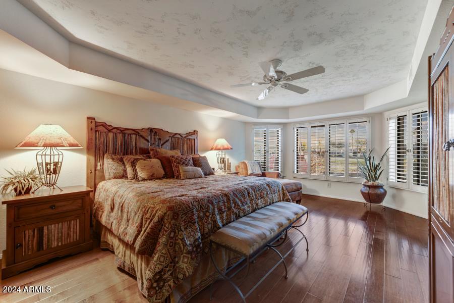 19049 East Poco Rio Drive Rio Verde, AZ 85263 - Photo 23 of 37 a spacious bedroom with a bed and wooden floor