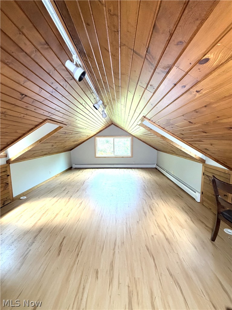 12590 Rockhaven Road Chesterland, OH 44026 - Photo 16 of 25 Spacious attic room featuring wood-finish flooring, a vaulted wood-paneled ceiling, and a large window providing natural light