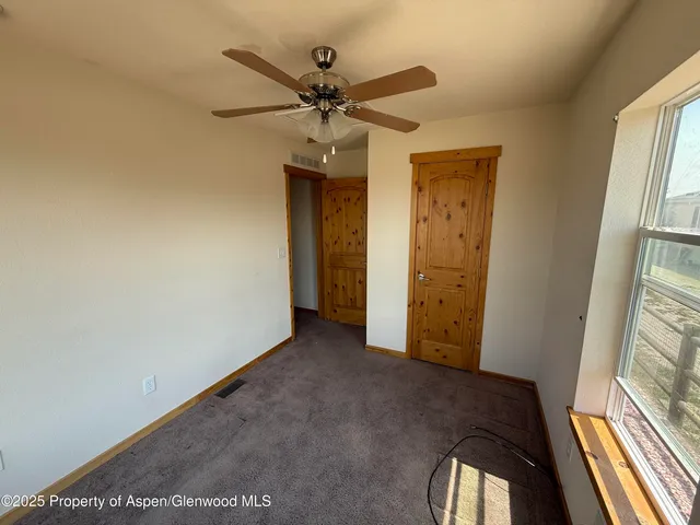 a view of a hallway with a chandelier fan and wooden floor