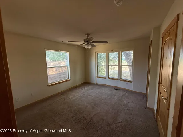 a view of a livingroom with a ceiling fan and window