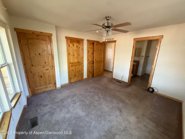 a view of empty room with wooden floor and window