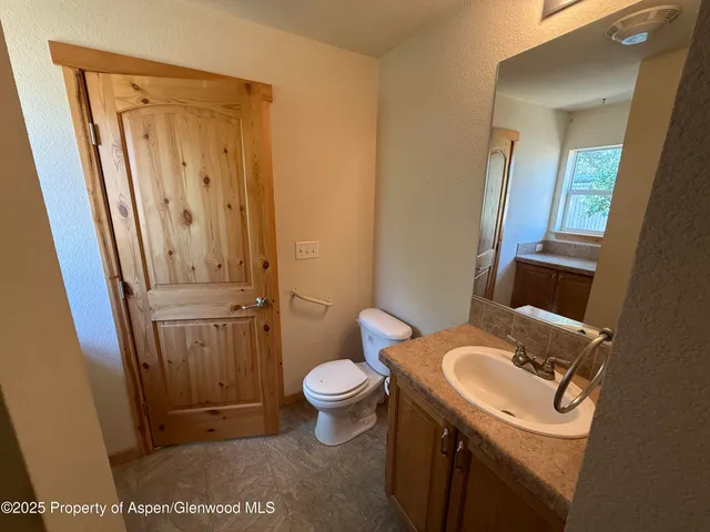 a bathroom with a sink a toilet and mirror