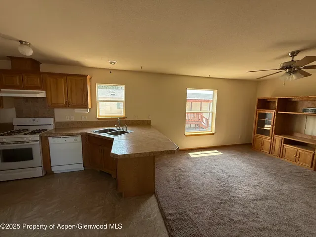 a kitchen with kitchen island granite countertop a sink stove and refrigerator