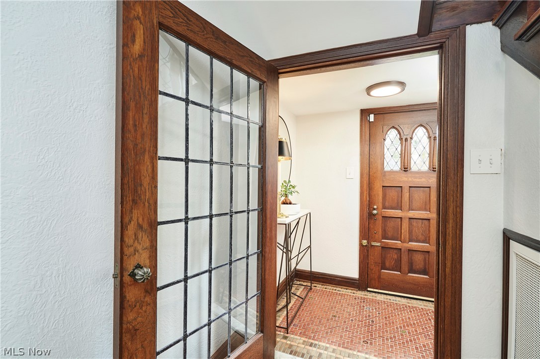 644 Ridgecrest Road Akron, OH 44303 - Photo 21 of 47 Hardwood frame door with divided light glass paneling opening into a foyer with a decorative wood entry door, leaded glass accents, and a tile floor