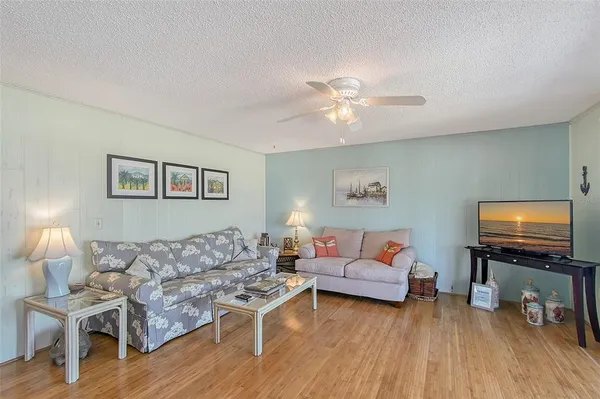 a living room with furniture a flat screen tv and wooden floor