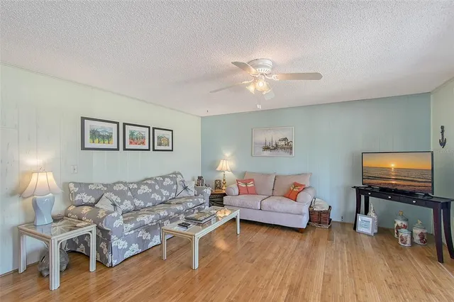 a living room with furniture a flat screen tv and wooden floor