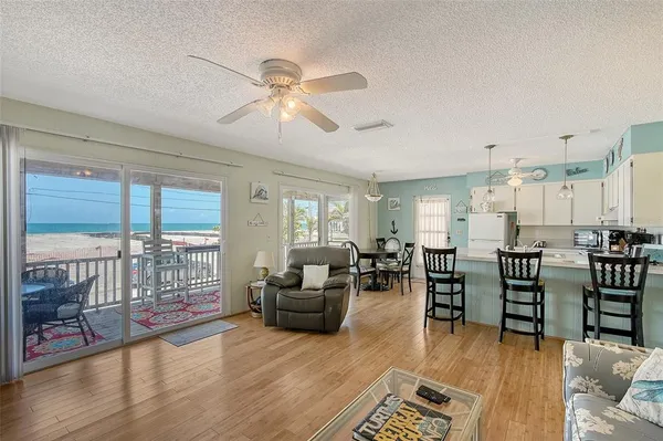 a living room with lots of furniture hardwood floor and a large window