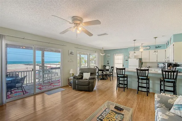 a living room with lots of furniture hardwood floor and a large window