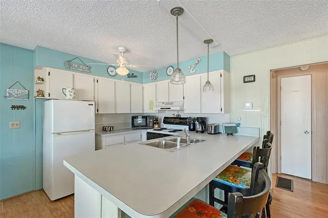 a kitchen with a refrigerator a sink dishwasher a stove a dining table and chairs