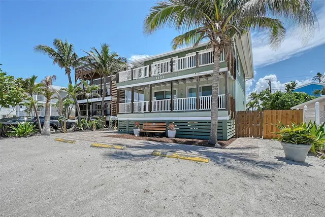 a row of palm trees in front of a house