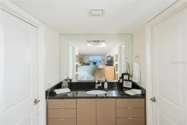 a bathroom with a granite countertop sink and a mirror