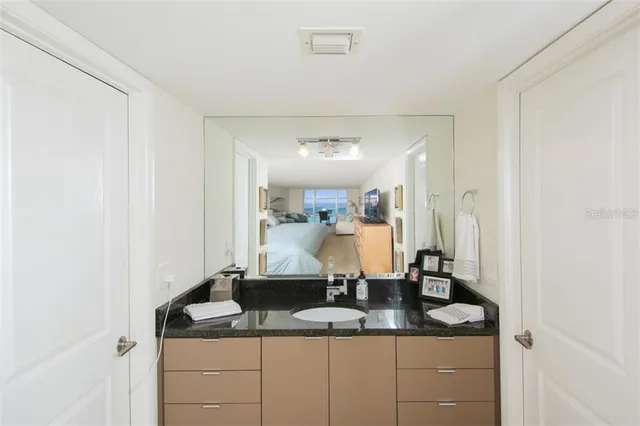 a bathroom with a granite countertop sink and a mirror