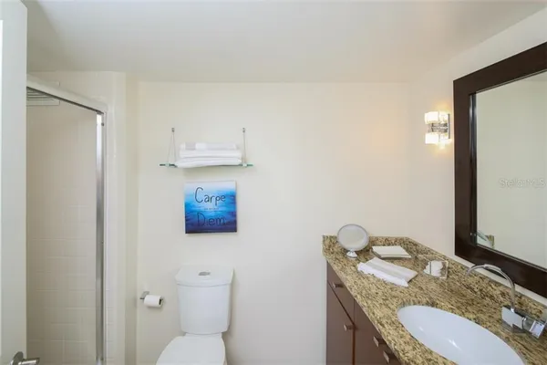 a bathroom with a granite countertop toilet and a sink