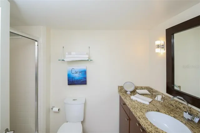 a bathroom with a granite countertop toilet and a sink