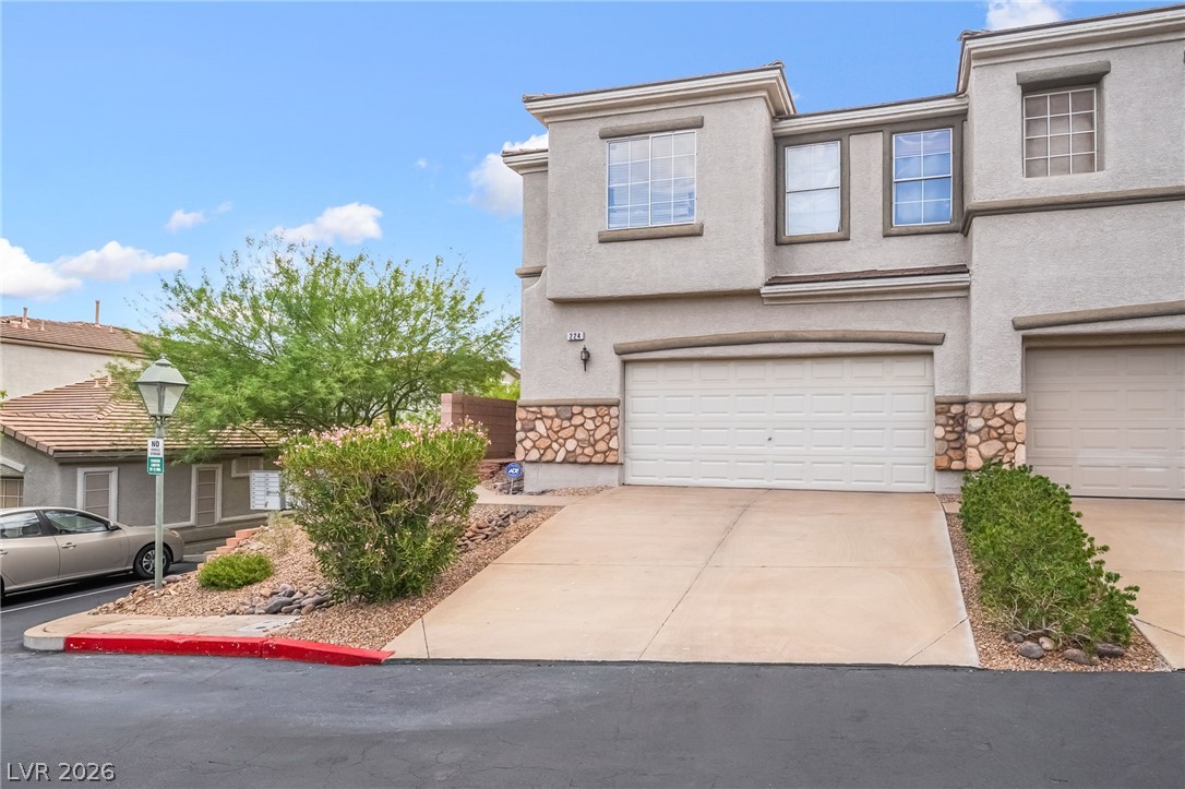 224 Positive Point Street Henderson, NV 89012 - Photo 3 of 44 Stucco exterior walls paired with stone veneer accents frame the spacious two-car garage.