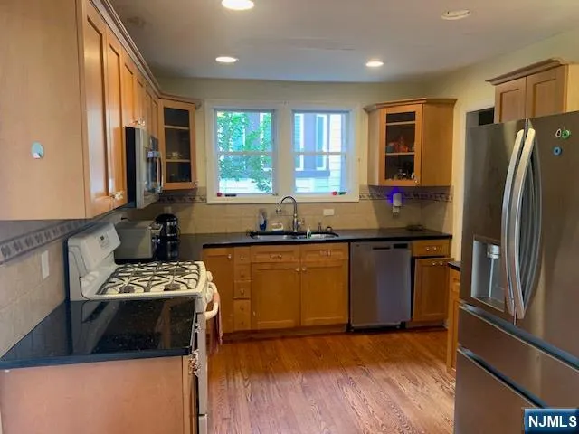 a kitchen with granite countertop a refrigerator and a sink