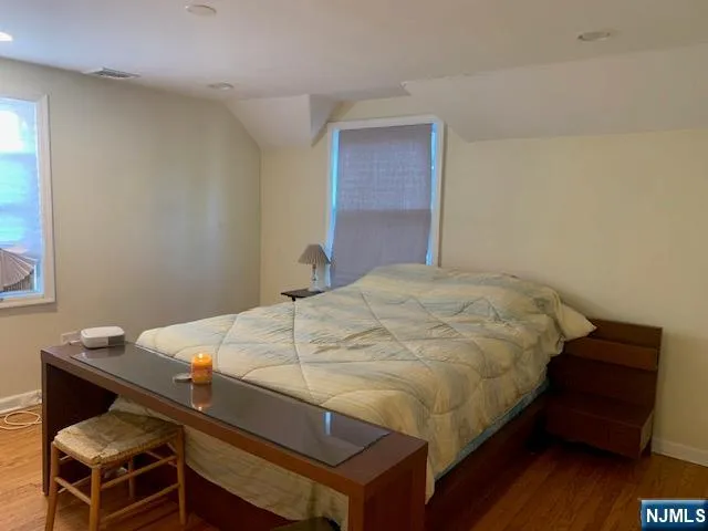 a bed sitting in a bedroom and wooden floor