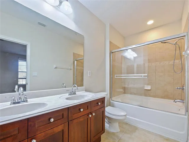 a bathroom with a granite countertop sink a toilet and bathtub