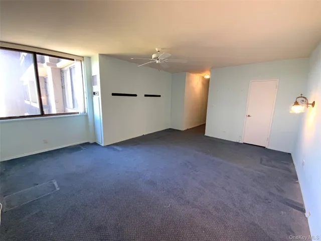 an empty room with windows and cabinet