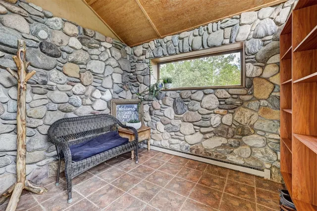 a living room with furniture floor to ceiling window and wooden floor