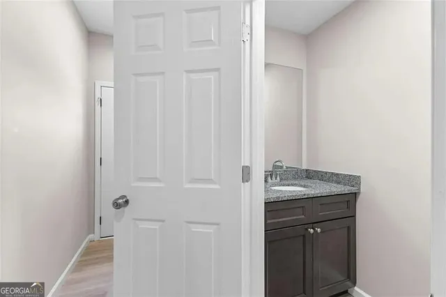a bathroom with a granite countertop sink and a mirror