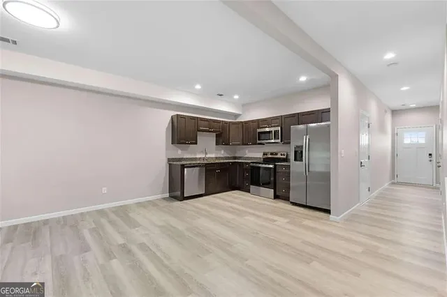 a kitchen with stainless steel appliances kitchen island sink refrigerator and cabinets