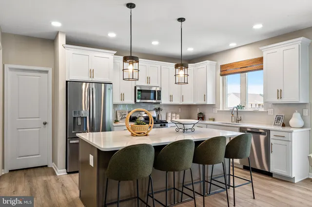 a kitchen with refrigerator cabinets dining table and chairs