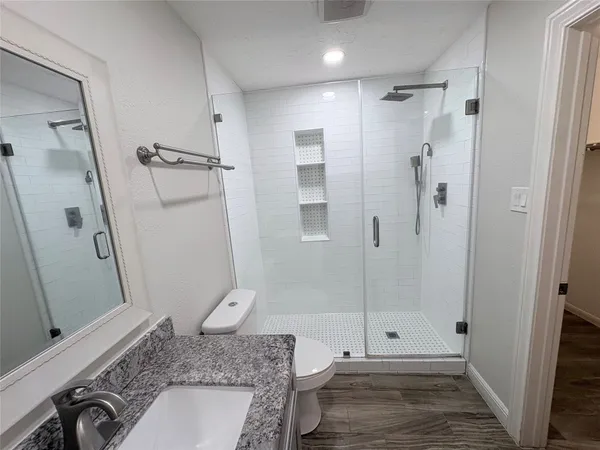 a bathroom with a granite countertop shower and a sink
