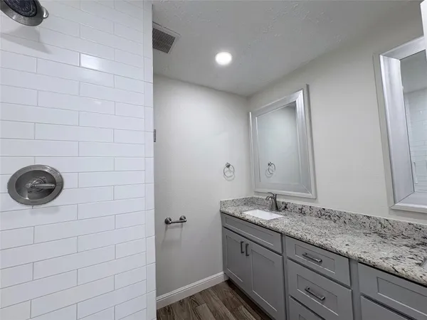 a bathroom with a granite countertop sink and a mirror