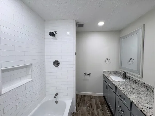 a bathroom with a granite countertop sink a toilet and shower