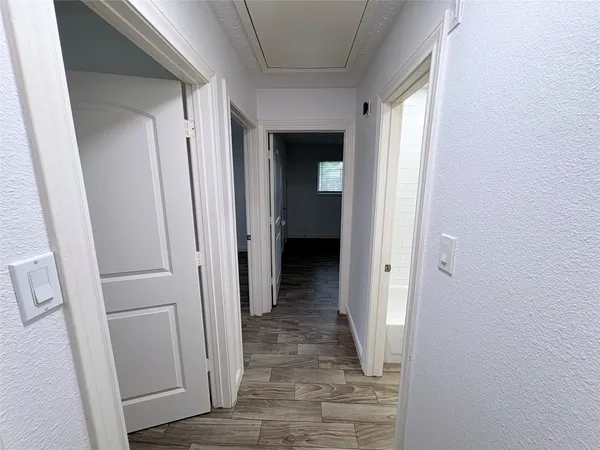 a view of a hallway with wooden floor and closet
