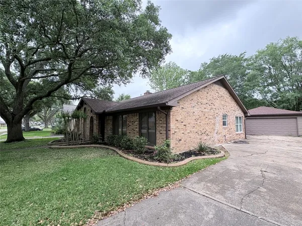 a view of a house with a yard and large tree