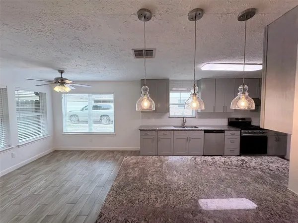 a kitchen with a stove a refrigerator and a wooden floor