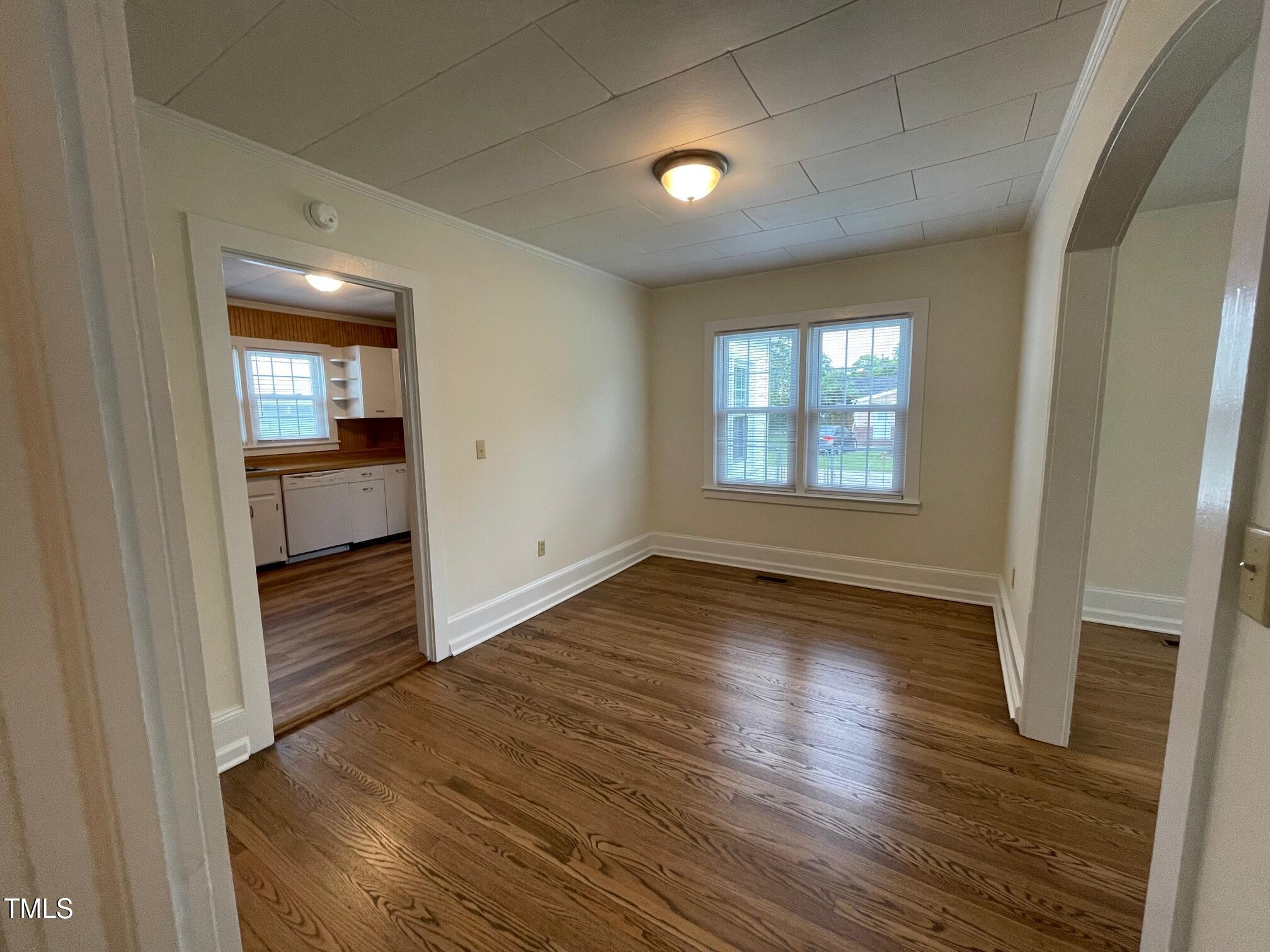 140 South Dunn Street Angier, NC 27501 - Photo 18 of 27 an empty room with wooden floor and windows