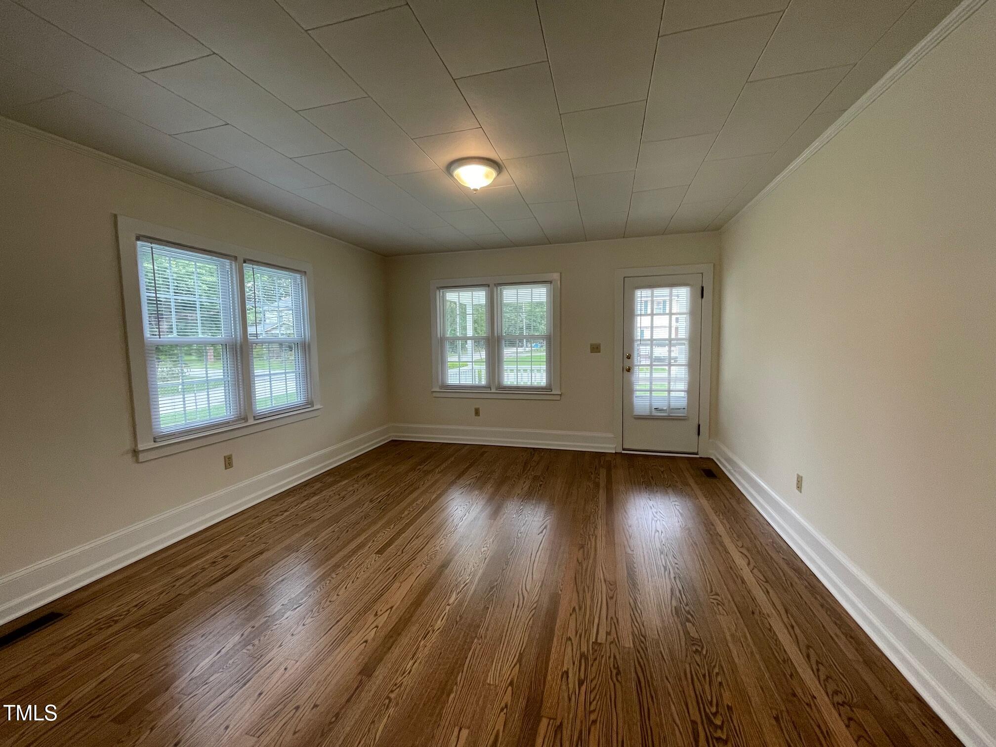 140 South Dunn Street Angier, NC 27501 - Photo 19 of 27 an empty room with wooden floor and windows