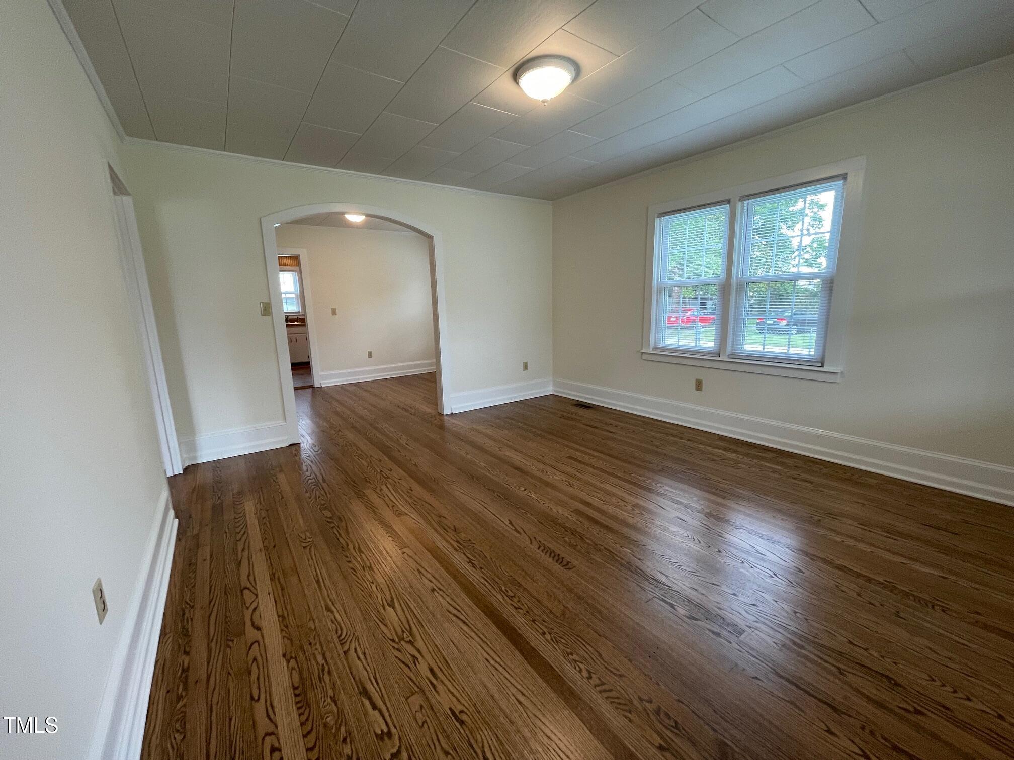 140 South Dunn Street Angier, NC 27501 - Photo 20 of 27 an empty room with wooden floor and windows